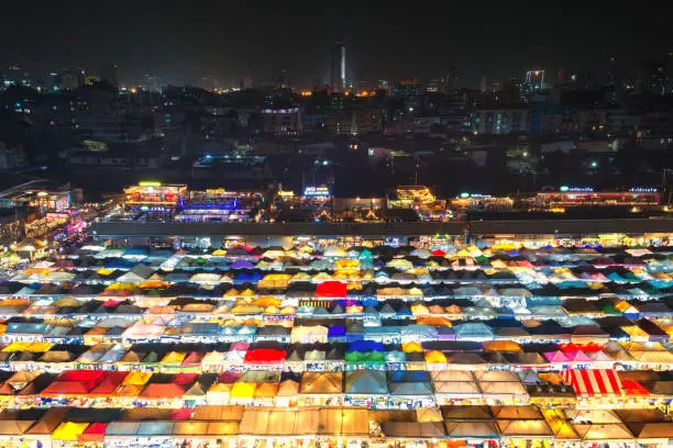 Photo of 02/02/2020 Bangkok, Thailand, Top view of Train Night Market Ratchada (Talad Rot Fai) flea market with plenty of shops with colorful canvas roofs near MRT line at night time in Bangkok