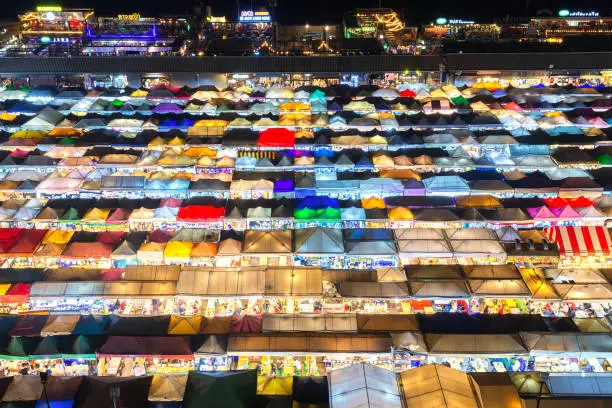 Photo of 02/02/2020 Bangkok, Thailand, Top view of Train Night Market Ratchada (Talad Rot Fai) flea market with plenty of shops with colorful canvas roofs near MRT line at night time in Bangkok