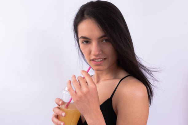 istock Brunette in lingerie drinking juice 1266259793