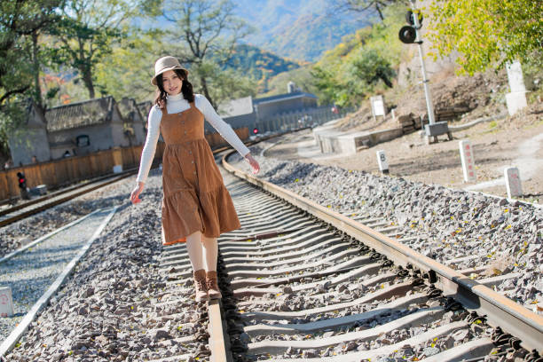 Young women walk on the railway tracks