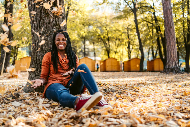 空気中に葉を投げる女性 - autumn women smiling leaf ストックフォトと画像