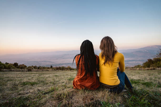 istock Multi-ethnic female friends sitting on meadow 1266264039