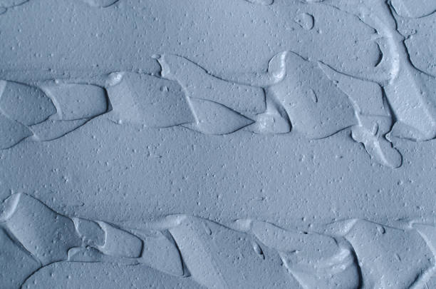 istock Gray bentonite facial clay (alginate mask, face cream, body wrap) texture close up, selective focus. Abstract background with brush strokes. 1266268132