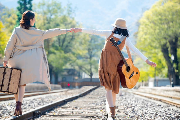 istock Young girlfriends go hand in hand on the rail 1266268137