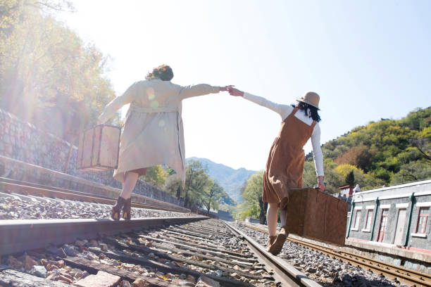 istock Young girlfriends go hand in hand on the rail 1266268169