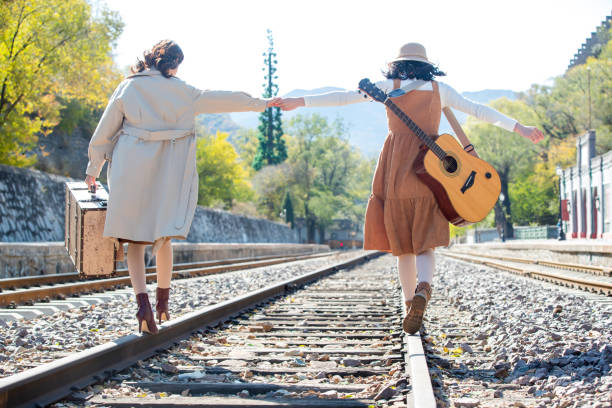 istock Young girlfriends go hand in hand on the rail 1266268221