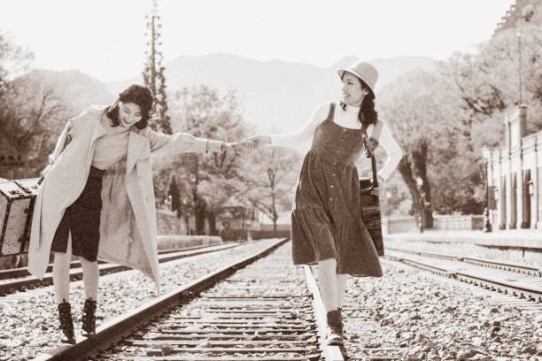 istock Young girlfriends go hand in hand on the rail 1266268250