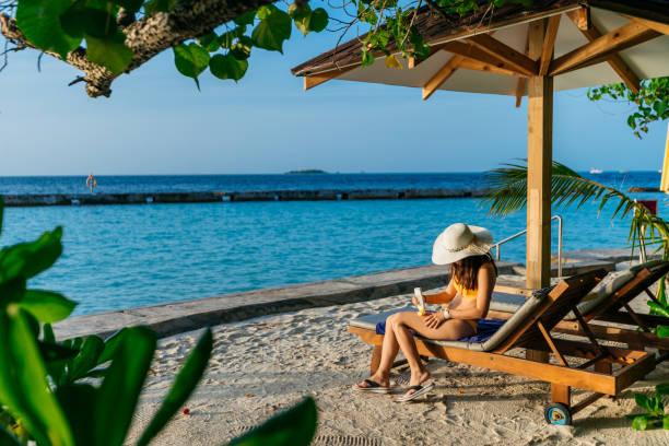istock Young woman applying suntan lotion 1266268257