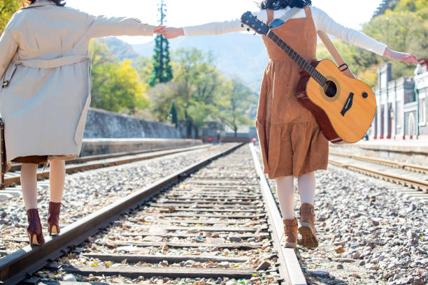 istock Young girlfriends go hand in hand on the rail 1266268279