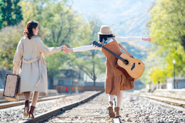 istock Young girlfriends go hand in hand on the rail 1266268280