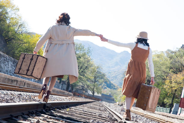 istock Young girlfriends go hand in hand on the rail 1266268298