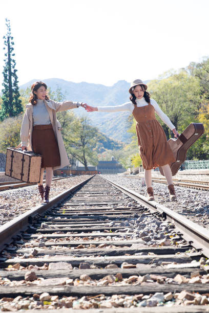 istock Young girlfriends go hand in hand on the rail 1266268299