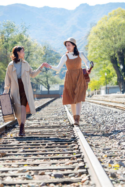 istock Young girlfriends go hand in hand on the rail 1266268302