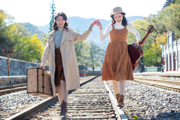 istock Young girlfriends go hand in hand on the rail 1266268303