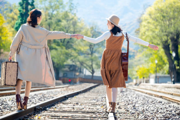 istock Young girlfriends go hand in hand on the rail 1266268328