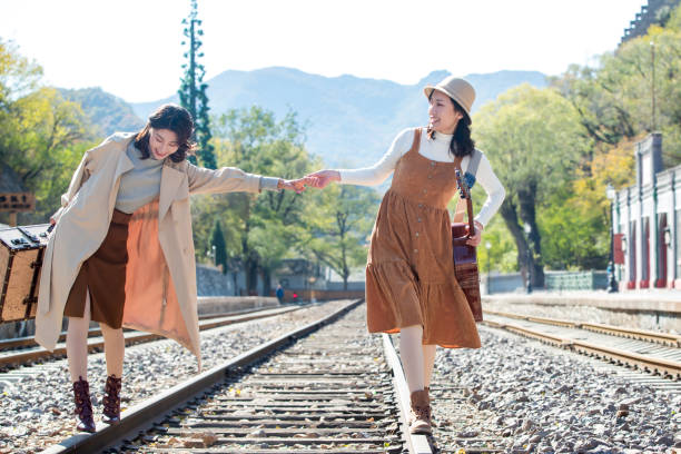 istock Young girlfriends go hand in hand on the rail 1266268329