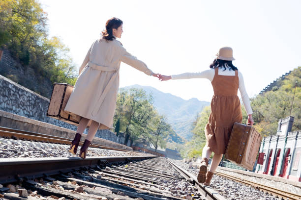 istock Young girlfriends go hand in hand on the rail 1266268333