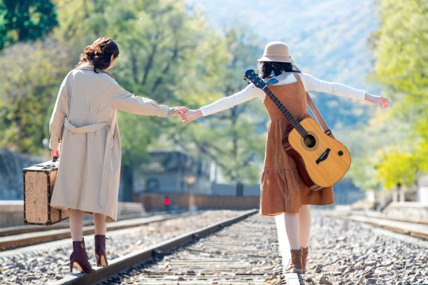 istock Young girlfriends go hand in hand on the rail 1266268339