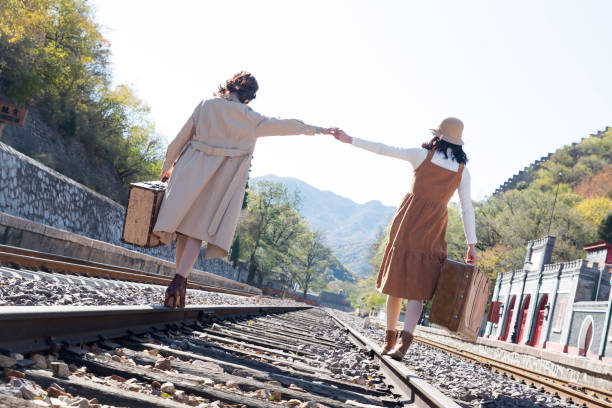 istock Young girlfriends go hand in hand on the rail 1266268358