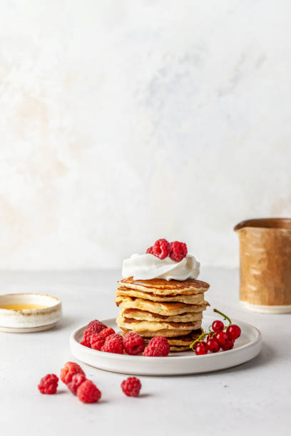 Pancakes with cream and raspberries stock photo