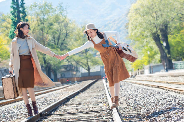 istock Young girlfriends go hand in hand on the rail 1266271093