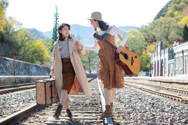 istock Young girlfriends go hand in hand on the rail 1266271102