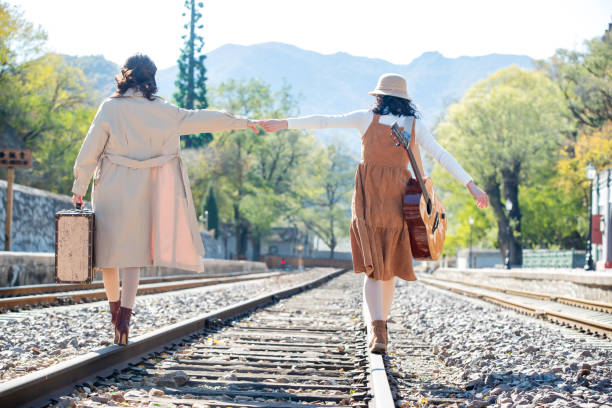 istock Young girlfriends go hand in hand on the rail 1266271108