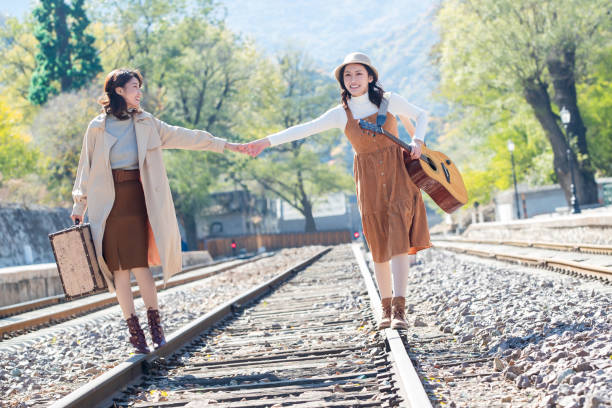 istock Young girlfriends go hand in hand on the rail 1266271139