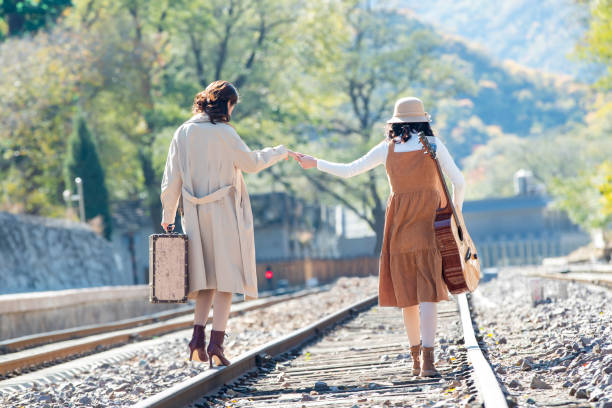istock Young girlfriends go hand in hand on the rail 1266271154