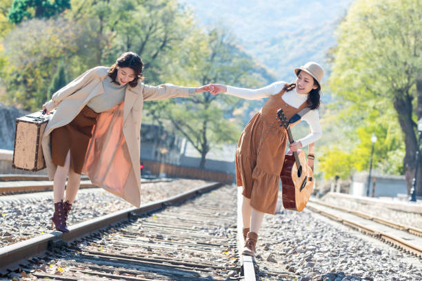 istock Young girlfriends go hand in hand on the rail 1266271156