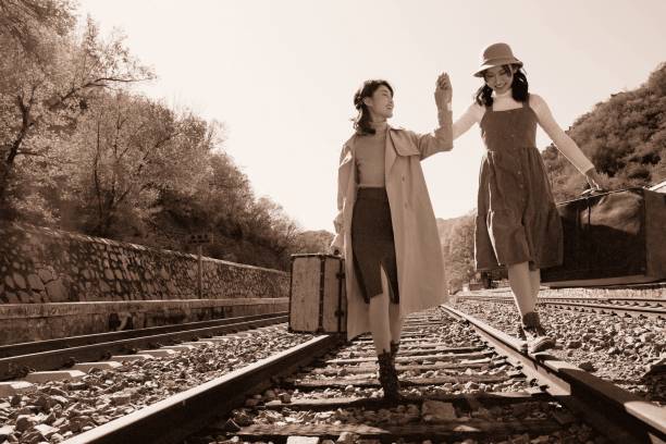istock Young girlfriends go hand in hand on the rail 1266271159