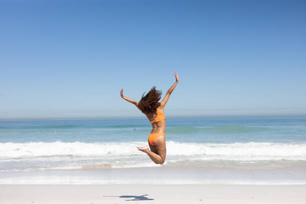 istock Mixed race woman jumping on the beach 1266275226