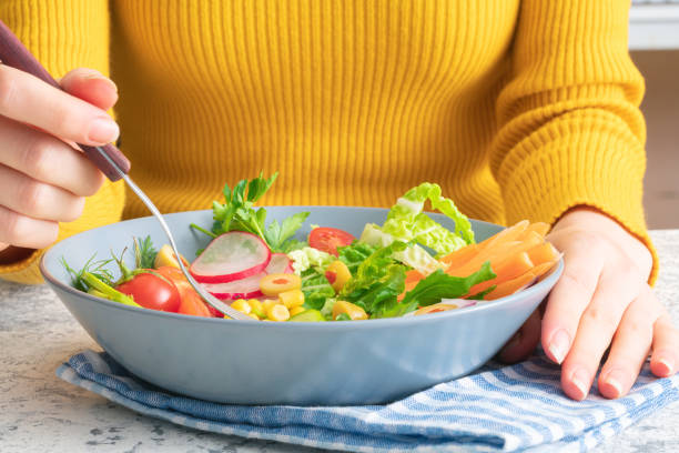 istock Woman eating vegan salad 1266275578