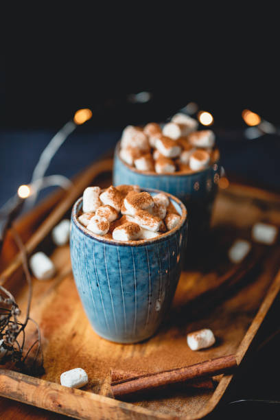 istock Hot chocolate with marshmallows and cinnamon in blue ceramic cups on a table. The concept of cozy holidays and New Year. 1266280694