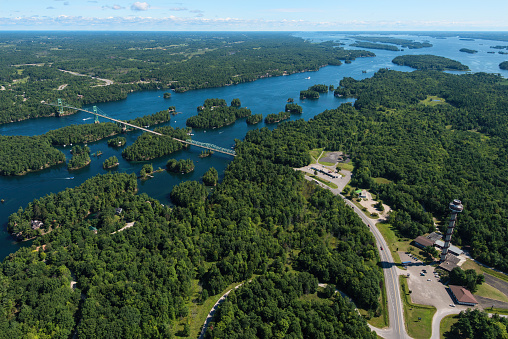 This aerial view of the Thousand Islands Bridge in Ontario, Canada shows the bridge spanning the St. Lawrence River and includes the Thousand Islands Tower. The bridge connects New York and southern Ontario.