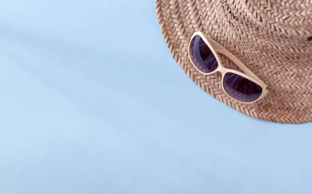 istock Summer straw hat beach and sunglasses on light blue background. Copy space. Top view. 1266285157