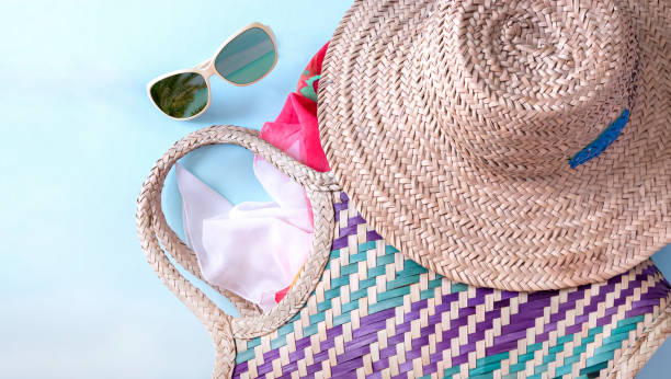 istock Summer straw hat beach, sunglasses  and shorts on light blue background. Copy space. Top view. 1266285170