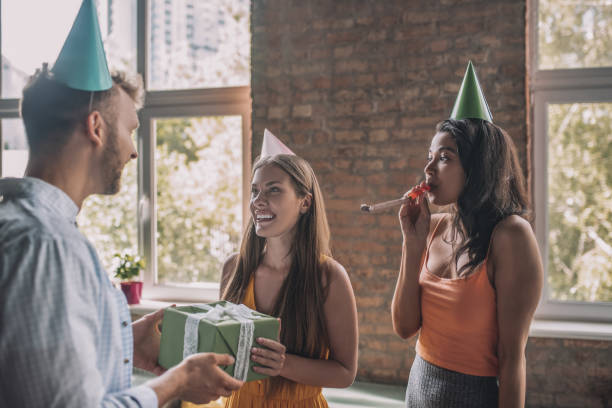 istock Man receiving a birthday gift from his friends 1266285371