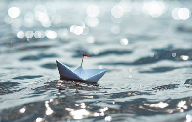 istock Paper Boat sailing on sunny sea 1266289122