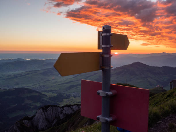 segni direzionali sul sentiero di montagna all'alba - direction arrow sign road sign escape foto e immagini stock