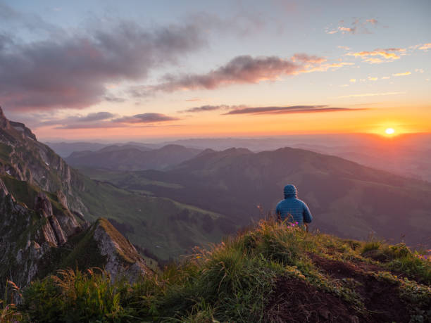istock Woman contemplating sunset from mountain top 1266292892