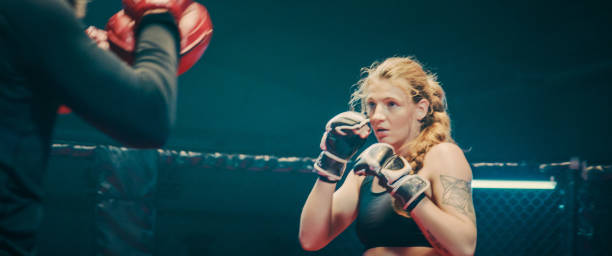 istock Female Boxer pad work session with trainer. Close up 1266293622