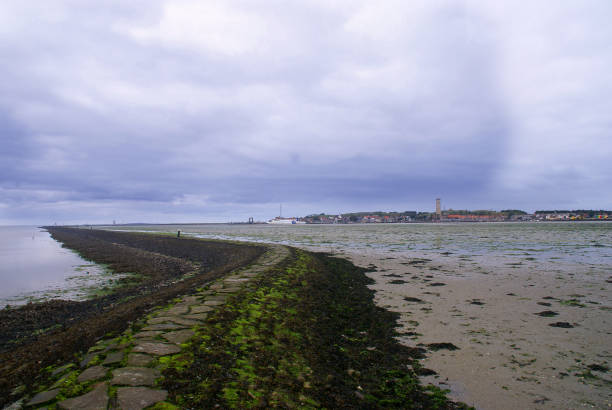 Threatening clouds over  the village of West-Terschelling at low tide, the Netherlands