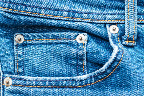 istock Jeans front with pocket and rivets. Bright blue denim fabric texture background. Closeup view 1266297517