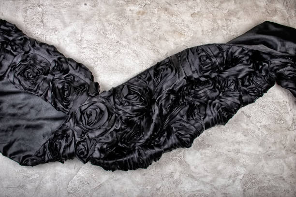 istock Monochrome image with black floral vintage wave-shaped fabric on white marble or concrete background 1266297686