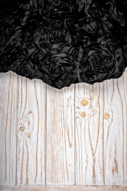 istock Black floral vintage fabric on white wooden background (vertical orientation) with copyspace for text 1266297713