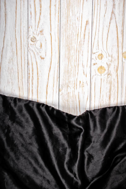 White wooden background and black vintage fabric, with copyspace for text