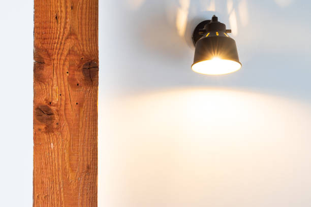 istock Light bulb at the wall lightens up an aged wooden beam. 1266297811