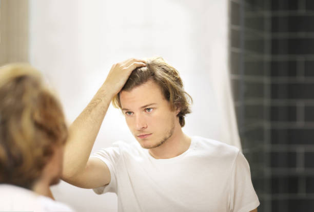 istock Applying the cream.young man looking in the mirror 1266299203