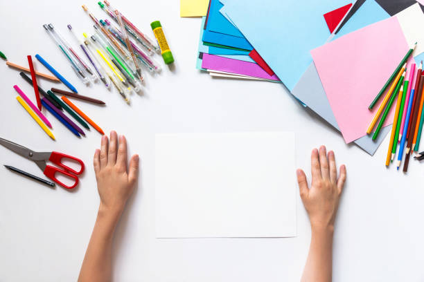 istock Unrecognizable child's hands drawing on blank paper. Top view 1266299451
